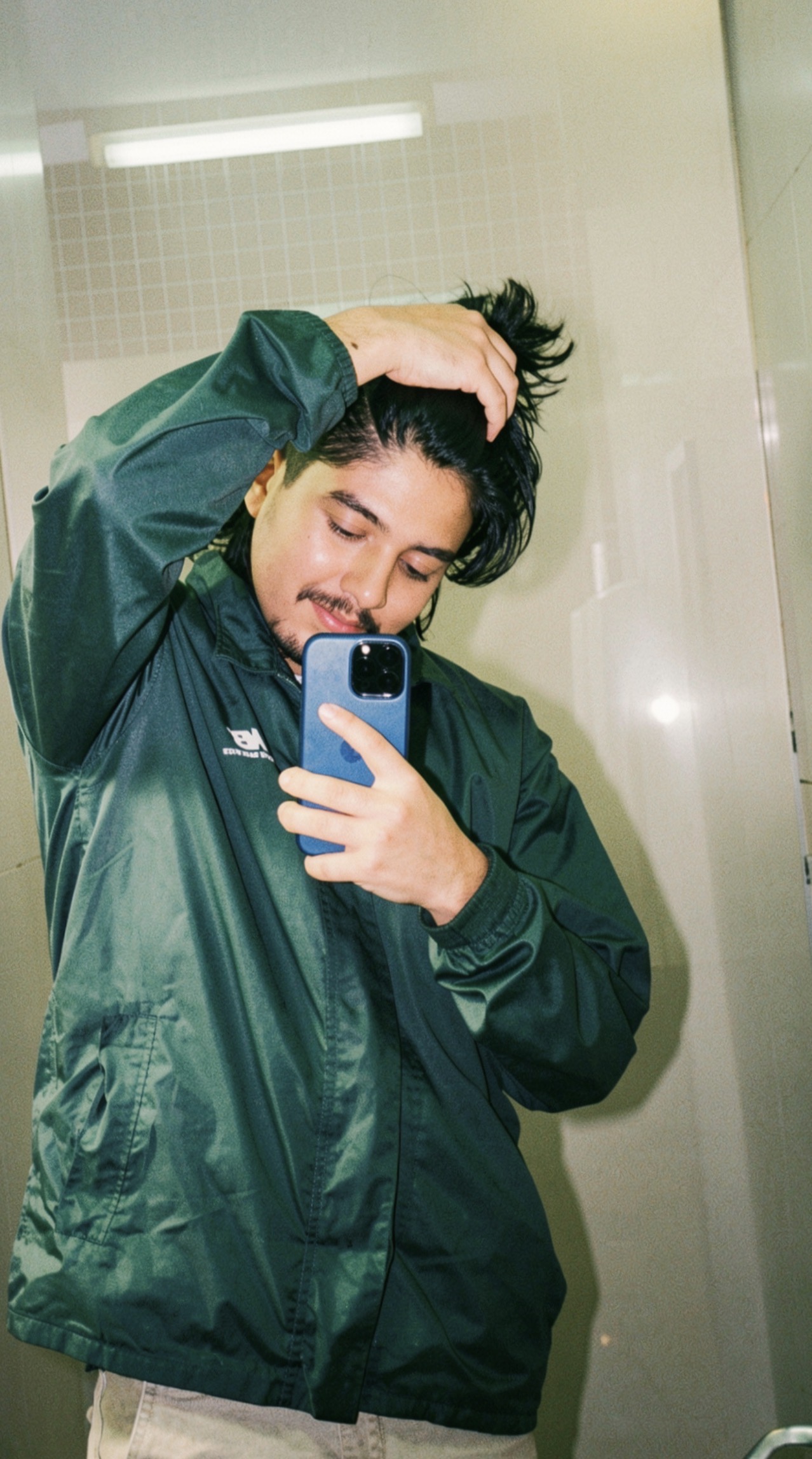 Kabiraj Bhatta taking a mirror portrait in a dark green jacket